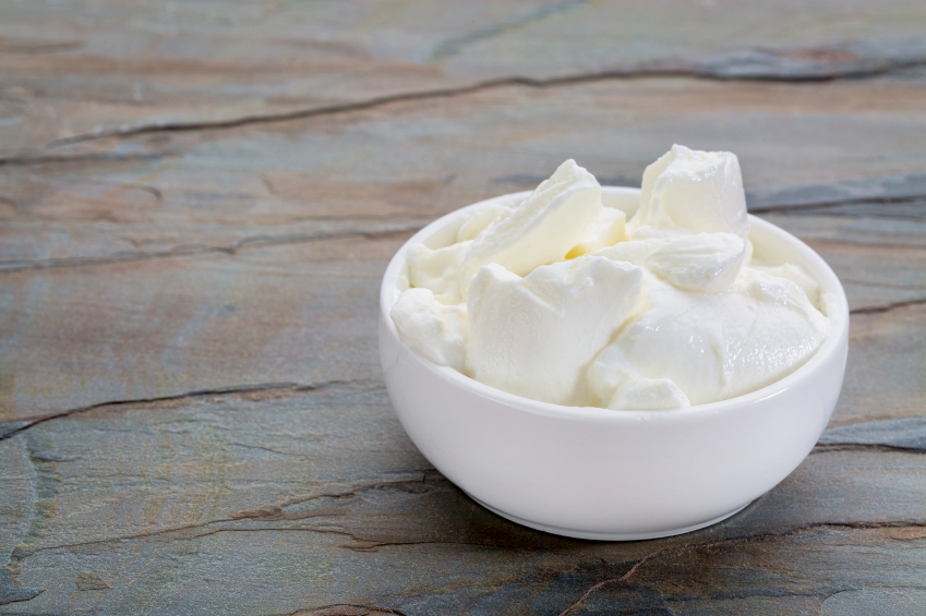a small white bowl of Greek yogurt against slate rock background